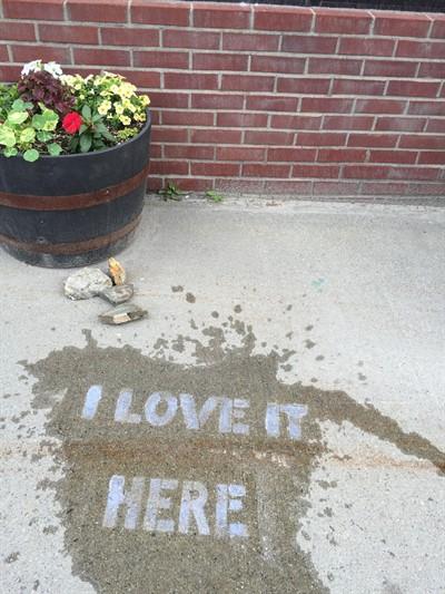 "I love it here" written on sidewalk