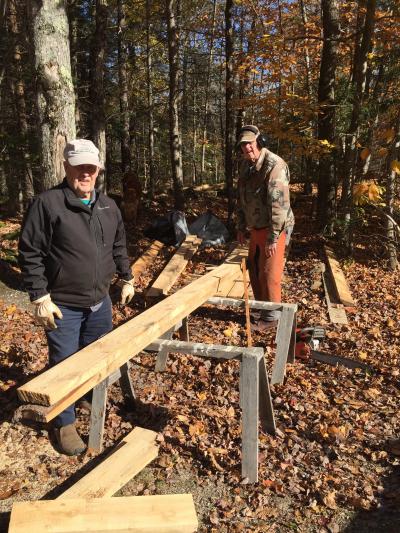 2 men with wood beam